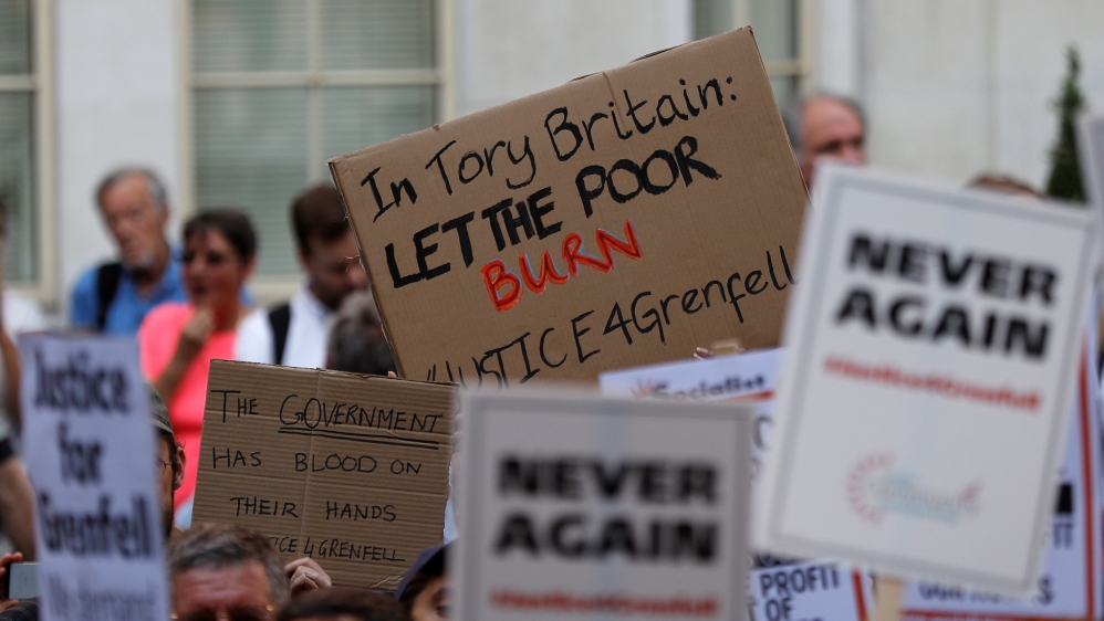 Demonstrators hold up banners during a march in Westminster, following the fire that destroyed The Grenfell Tower block, in north Kensington, West London