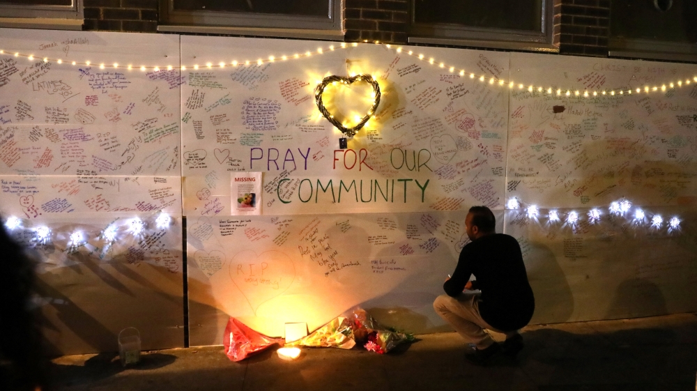 A man reads messages of condolence on a wall near a tower block severely damaged by a serious fire, in north Kensington, West London