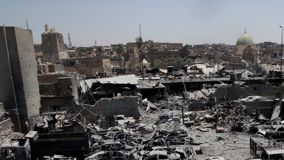 A destroyed al-Hadba minaret at Grand al-Nuri Mosque (L) is seen with the ruins of the mosque and other destroyed houses from the Iraqi forces positions at the Old City in Mosul
