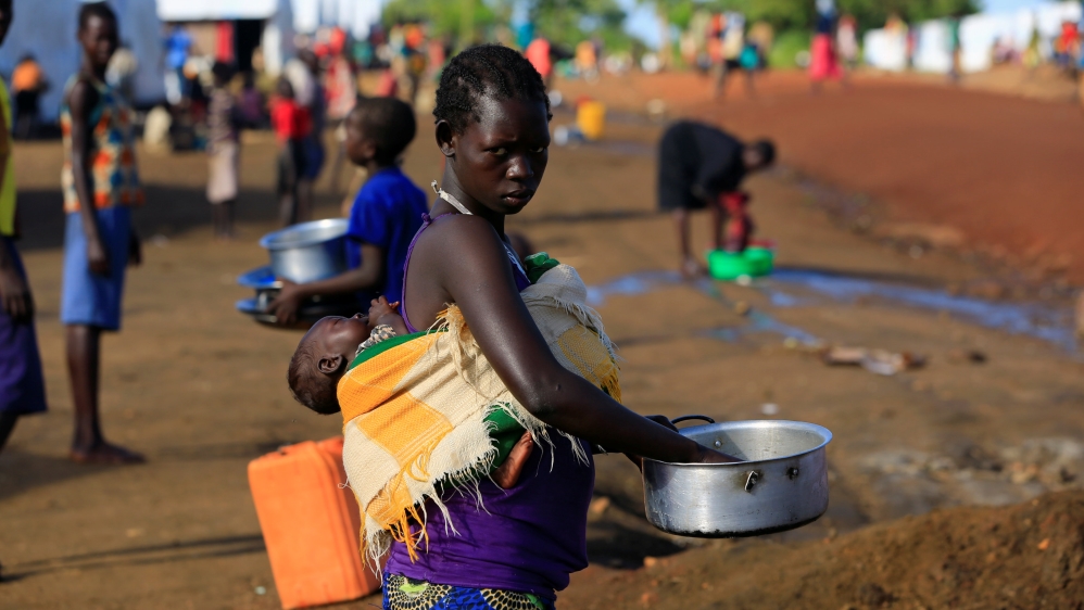 South Sudanese refugee woman cleans pot at Palabek Camp in Lamwo