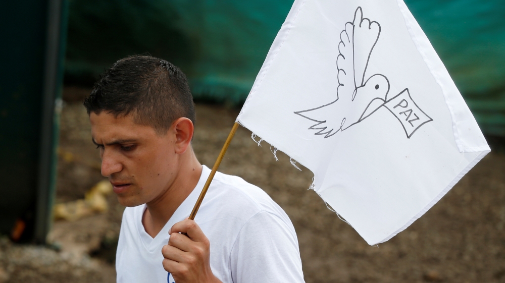 A FARC rebel waves a peace flag during the final act of abandonment of arms in Mesetas