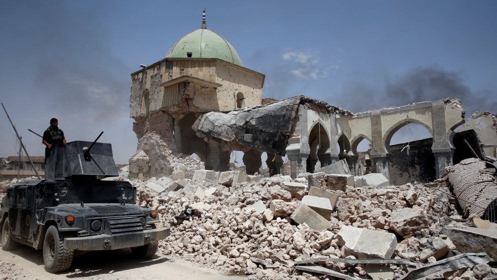 A member of Iraqi forces mans the turret of an armoured fighting vehicle past the ruined Grand al-Nuri Mosque in the Old City in Mosul