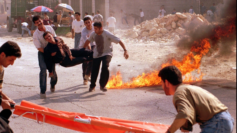 An injured Palestinian youth is carried to a stretcher as Palestinians clashed with Israeli troops during a protest against an Israeli tunnel under the al-Aqsa Mosque in Jerusalem on September 25, 1996 [AP Photo/Khaled Zighari]