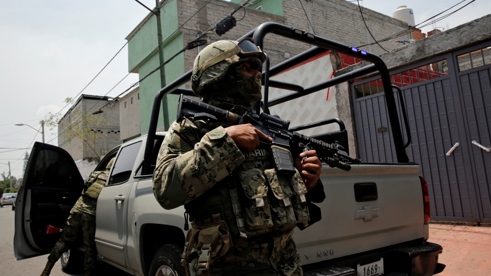 Mexican marine soldiers stand guard outside a house after suspected gang members were killed on Thursday in a gun battle with Mexican marines in Mexico City