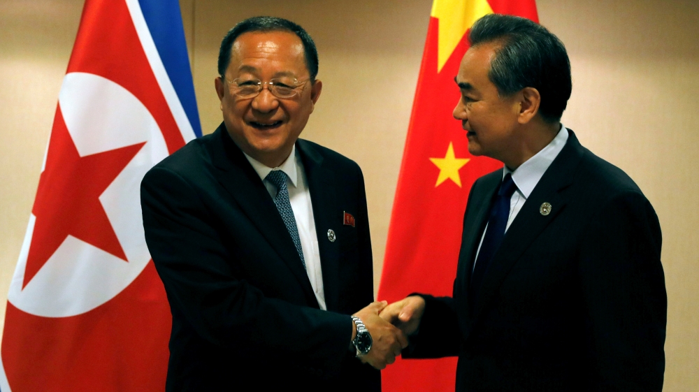 China's Foreign Minister Wang Yi, right, shakes hands with North Korea's Foreign Minister Ri Yong-ho before their bilateral meeting [Reuters]