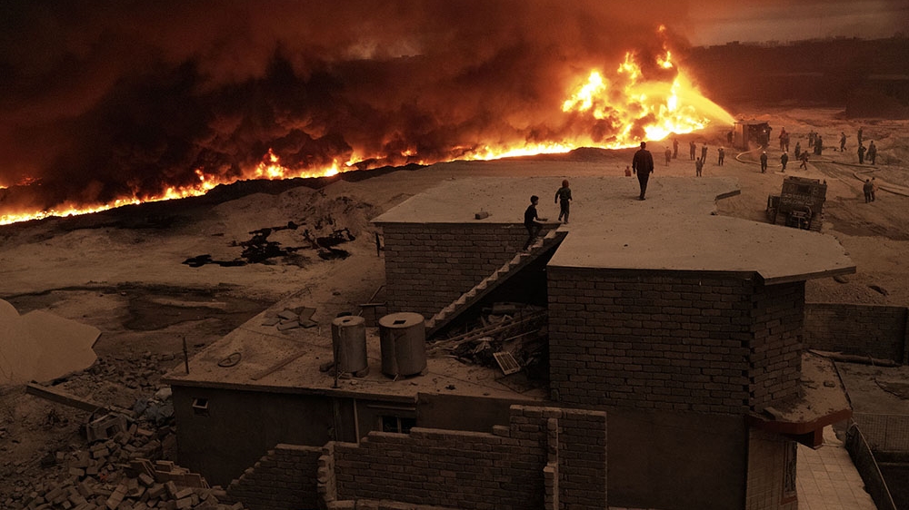 Firefighters struggled to contain the ring of fire that engulfed Qayyara after ISIL's retreat to Mosul [Joey Lawrence/Al Jazeera]