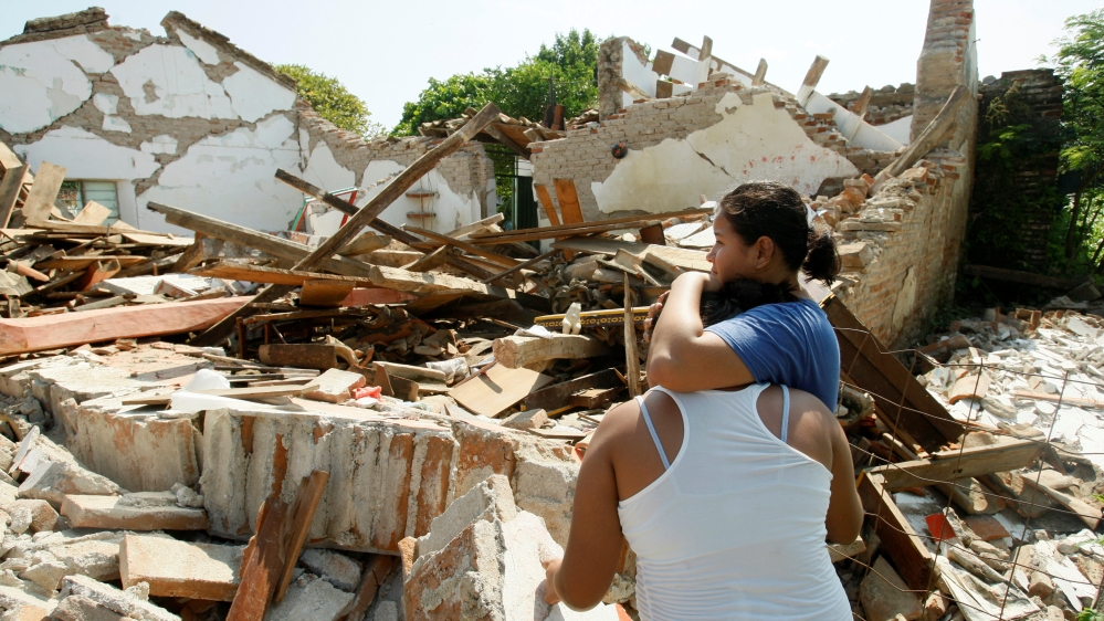 Women hug while standing next to a destroyed house after an earthquake struck the southern coast of Mexico late on Thursday, in Union Hidalgo