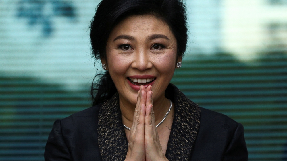 Ousted former Thai prime minister Yingluck Shinawatra greets supporters as she arrives at the Supreme Court in Bangkok