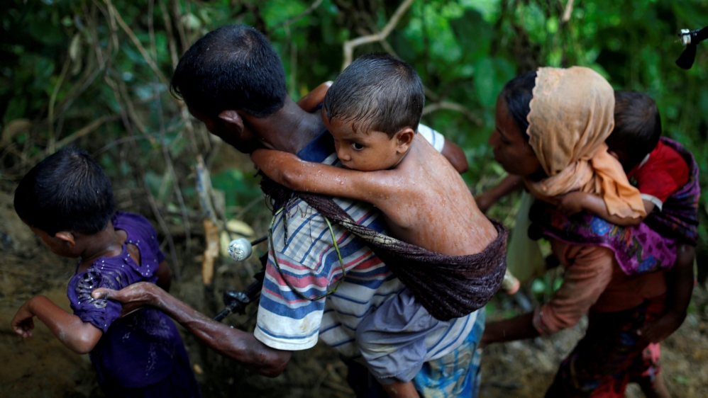 Rohingya refugees climb up a hill after crossing the Bangladesh-Myanmar border in Cox''s Bazar