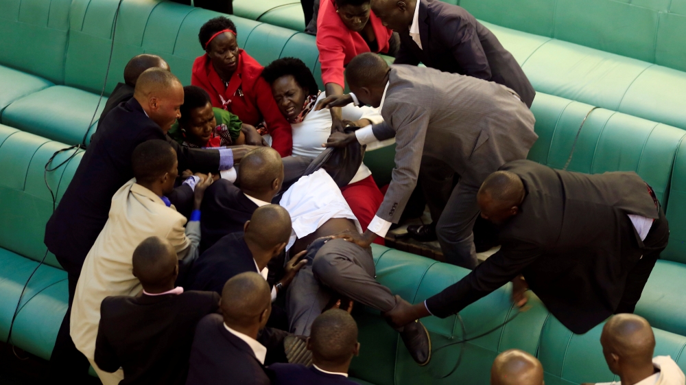 Ugandan opposition lawmakers fight with plain-clothes security personnel in the parliament while protesting a proposed age limit amendment bill debate, in Kampala