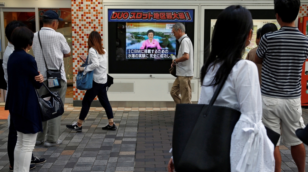 People walk past a street monitor showing a news report about North Korea''s nuclear test, in Tokyo