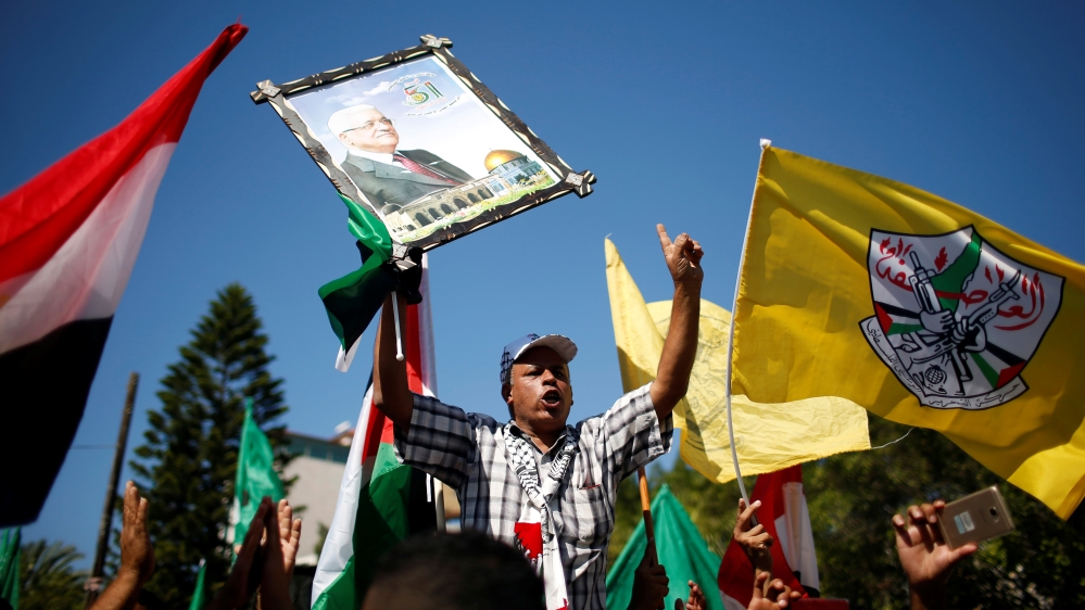 A man holds a picture of Palestinian President Mahmoud Abbas during celebrations after Hamas said it reached a deal with Palestinian rival Fatah, in Gaza City