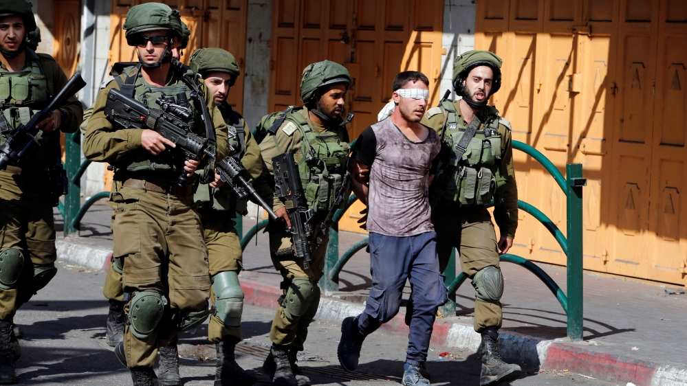 Israeli soldiers detain a Palestinian protester during clashes in the West Bank city of Hebron, September 29, 2017 [Mussa Qawasma/Reuters]