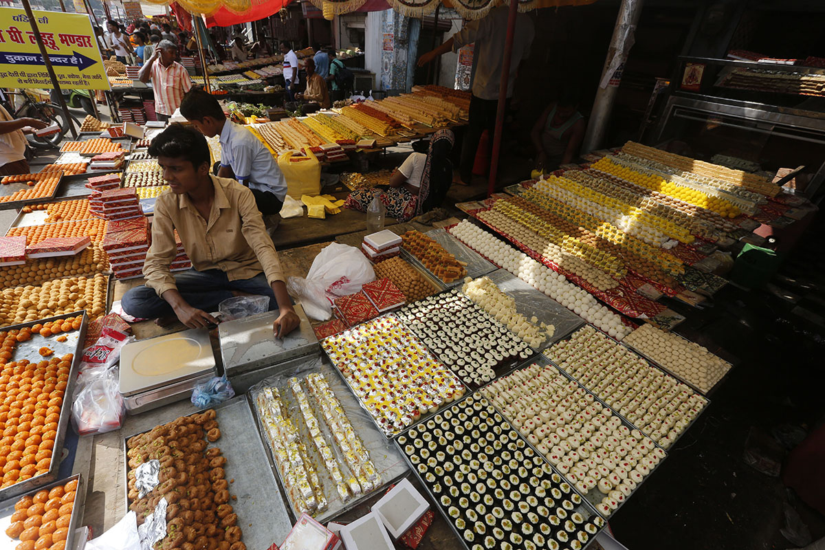 An Indian vendor displays sweets for sale on Diwali, the festival of lights, in Allahabad, India, Thursday, Oct. 19, 2017. Hindus light lamps, wear new clothes, exchange sweets and gifts and pray to g