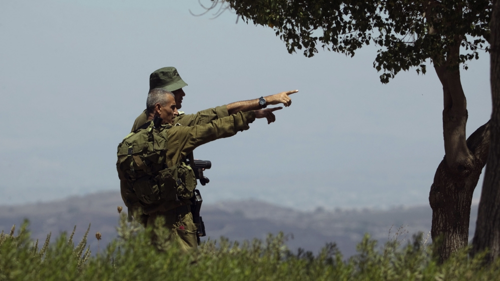 
Israeli soldiers observe the Syrian side of the Quneitra border crossing between the Israeli-occupied Golan Heights and Syria [Ronen Zvulun/Reuters]
