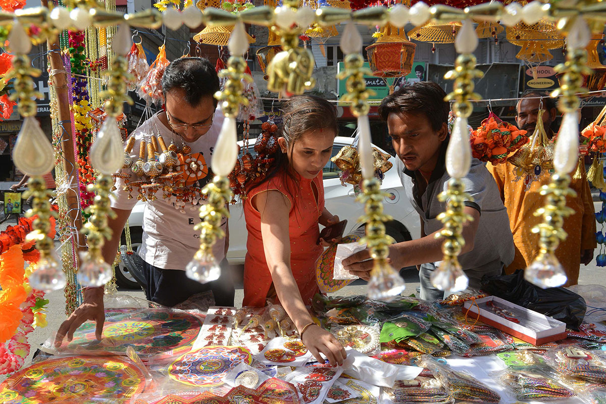 Indian customers look at decorative items ahead of Diwali festival at a roadside stall in Amritsar on October 16, 2017. / AFP PHOTO / NARINDER NANU (Photo credit should read NARINDER NANU/AFP/Getty Im