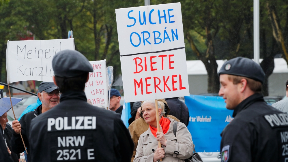 Members of Germany's far-right AfD protest against German Chancellor Angela Merkel in Dortmund, Germany on August 12, 2017. The placard reads,