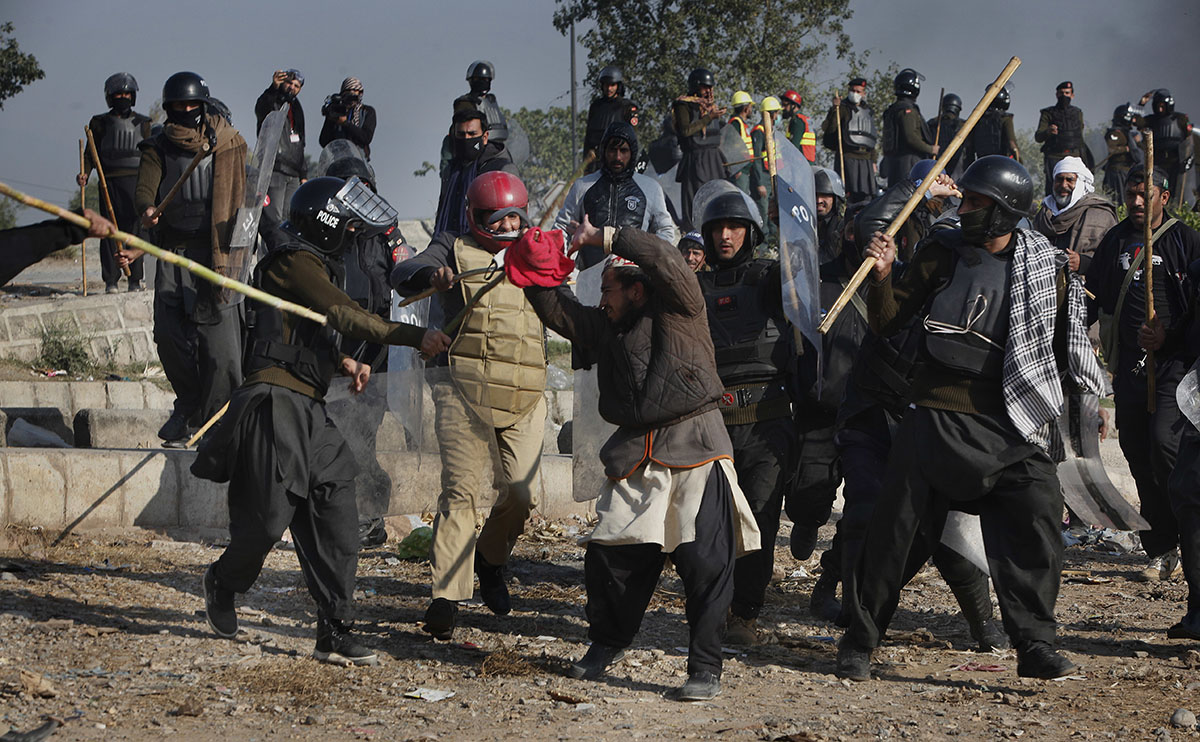 Pakistani police officers beat a protester during a clash in Islamabad, Pakistan, Saturday, Nov. 25, 2017. Pakistani police have launched an operation to clear an intersection linking capital Islamaba