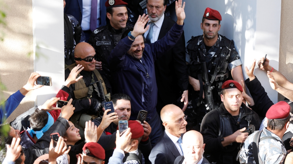 Saad al-Hariri who suspended his decision to resign as prime minister gestures to his supporters at his home in Beirut