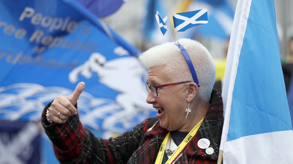 A woman gestures at a pro Independence rally held outside the SNP conference in Glasgow