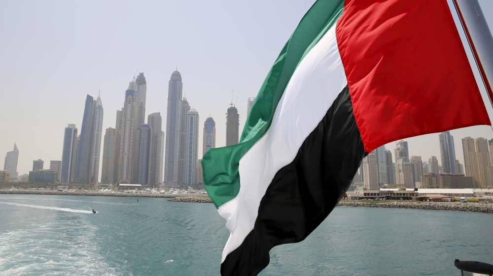 UAE flag flies over a boat at Dubai Marina,