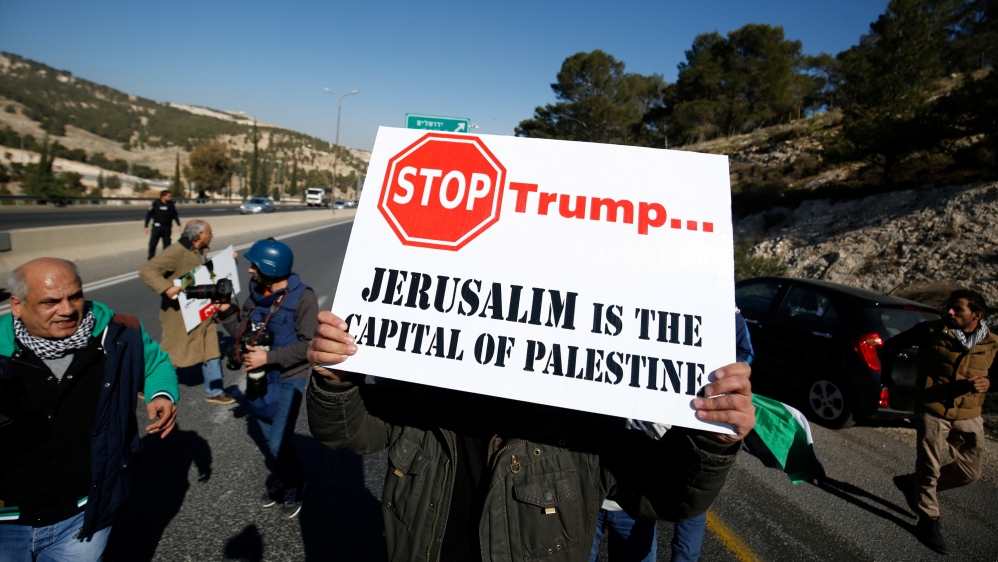 Palestinian demonstrator holds placard during a protest against a promise by U.S. President-elect Donald Trump to re-locate U.S. embassy to Jerusalem, in the West Bank near Jewish settlement