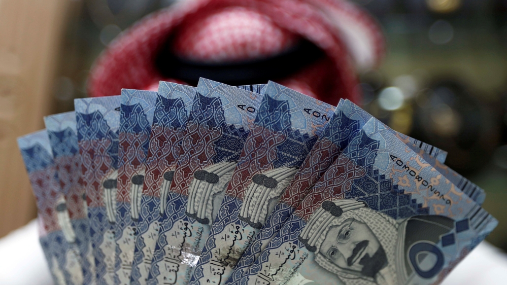 Saudi money changer displays Saudi Riyal banknotes at a currency exchange shop in Riyadh