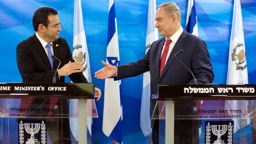 Guatemalan President Jimmy Morales and Israeli Prime Minister Benjamin Netanyahu reach out to shake hands as they deliver statements to the media during their meeting in Jerusalem
