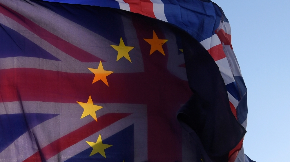 An EU flag and Union flag are seen flying together during an anti-Brexit protest near the Houses of Parliament in London