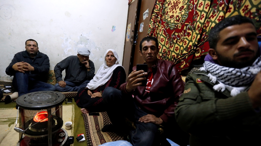 Palestinian refugee family watches a televised broadcast Trump in Amman