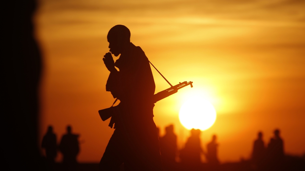 Rebel fighters walk in a rebel controlled territory in Upper Nile State