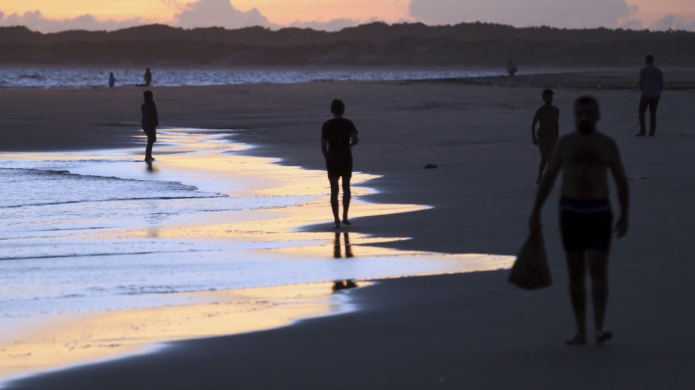People walk on Shela beach in Lamu, an island in the Indian Ocean off the northern coast of Kenya