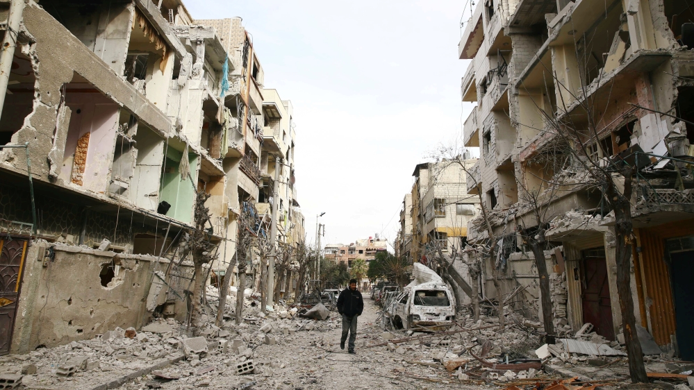 A man walks on a damaged street in the besieged town of Douma, Eastern Ghouta, Damascus