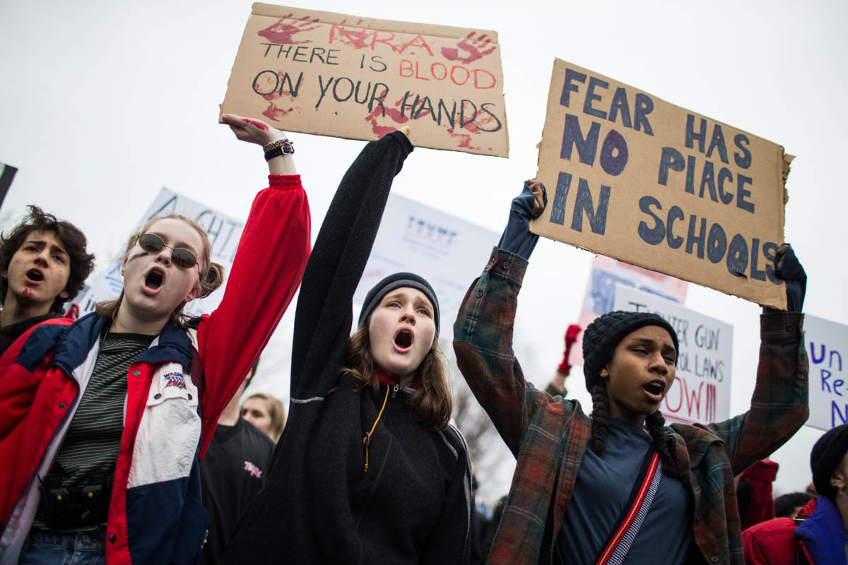 Demonstrators hold signs during a ''lie-in'' demonstration supporting gun control reform near the White House on February 19, 2018 in Washington, DC. According to a statement from the White House, ''the