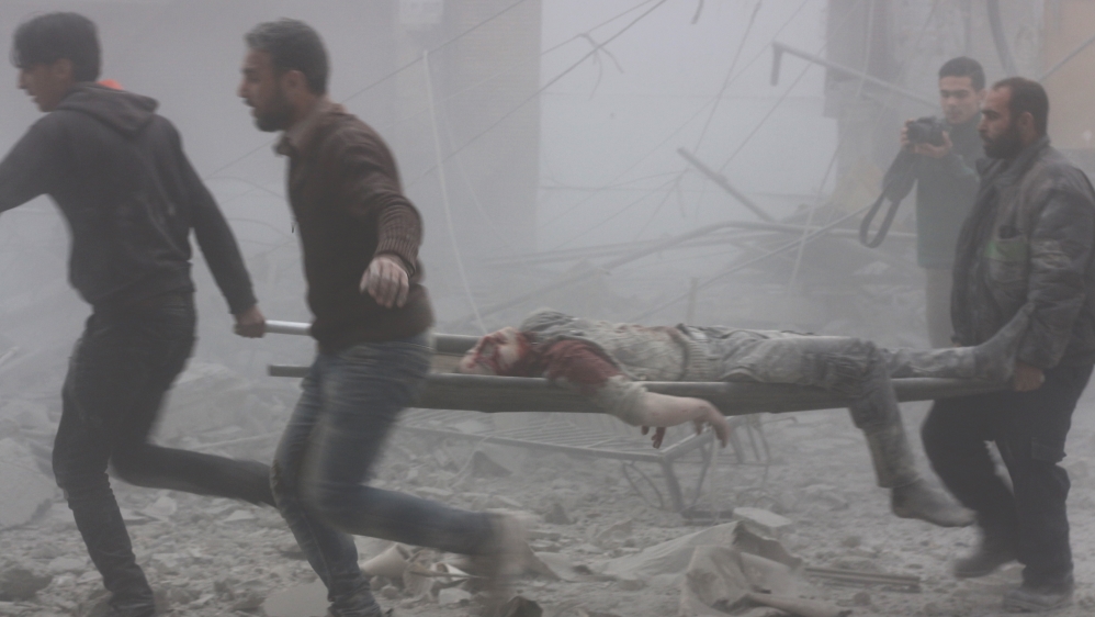 Syrians carry a wounded man after a government air strike hit residential areas in Eastern Ghouta's Douma town [Anadolu] 
