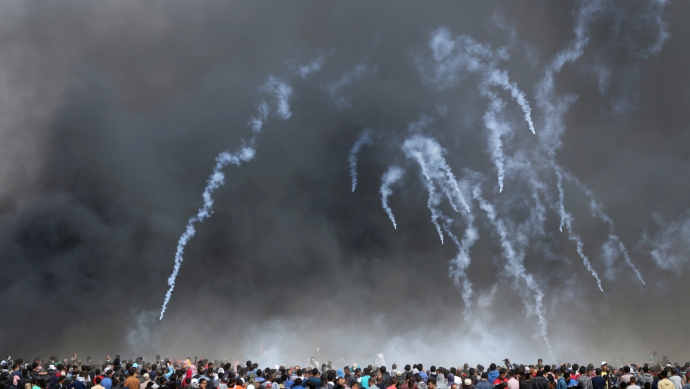 Tear gas canisters are fired by Israeli troops at Palestinian demonstrators during a protest demanding their right to return to their homeland [Ibraheem Abu Mustafa/ Reuters]