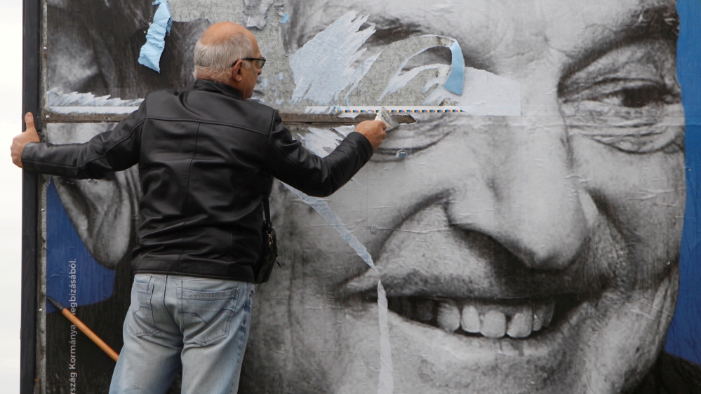 Activists of Egyutt (Together) opposition party removes a government billboard in Budapest