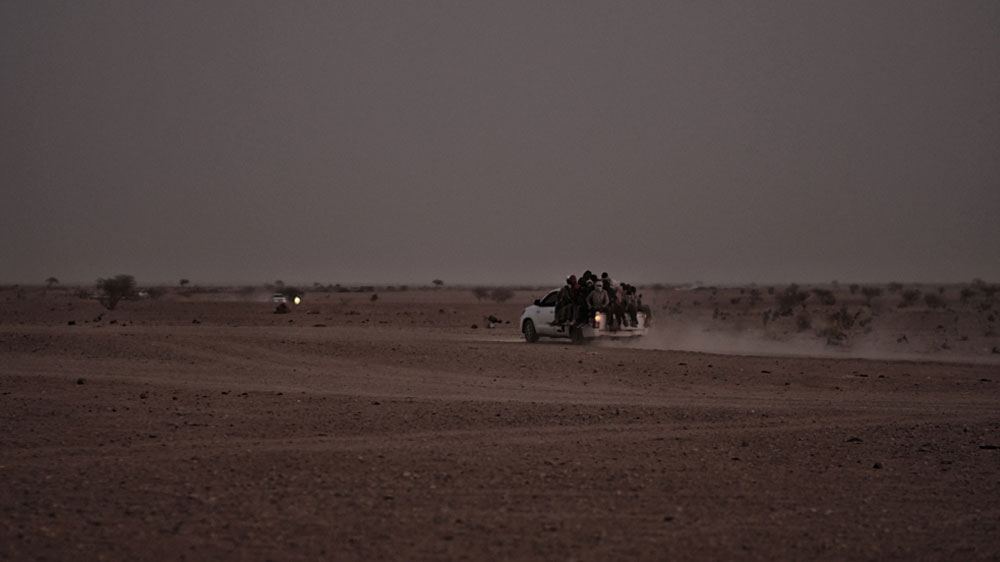 A pick-up truck packed with migrants runs on the route from Agadez to Libya [Giacomo Zandonini/Al Jazeera]