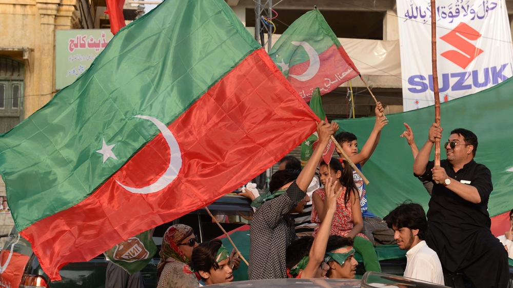 PTI supporters celebrate following the end of the polling in the general elections. Local media, projecting results from the partial and unofficial results, are showing PTI in an early lead [Muhammad Reza/Anadolu Agency/Getty Images]