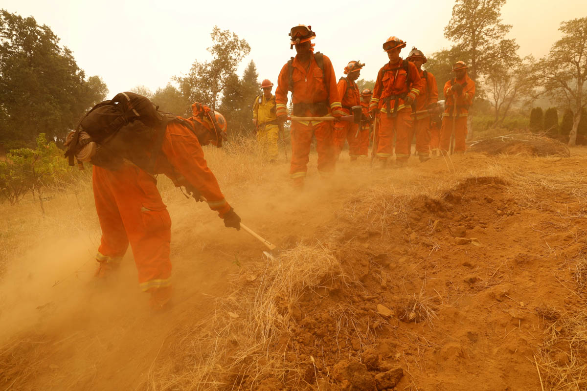 An inmate fire crew cuts fire lines in hot and smoky conditions while working to stop the spread of the Carr Fire, west of Redding, California, U.S. July 27, 2018. REUTERS/Fred Greaves TPX IMAGES OF T