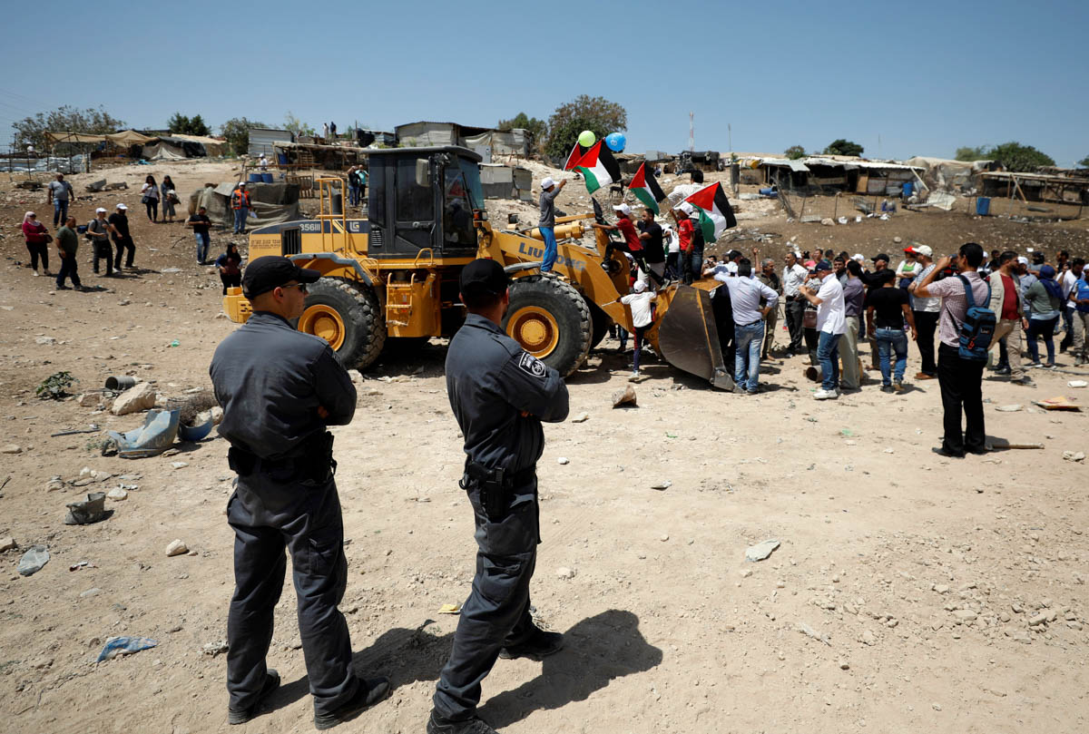 A Palestinian woman argues with an Israeli soldier as she rides on an Israeli bulldozer in the Palestinian Bedouin village of al-Khan al-Ahmar near Jericho in the occupied West Bank July 4, 2018. REUT