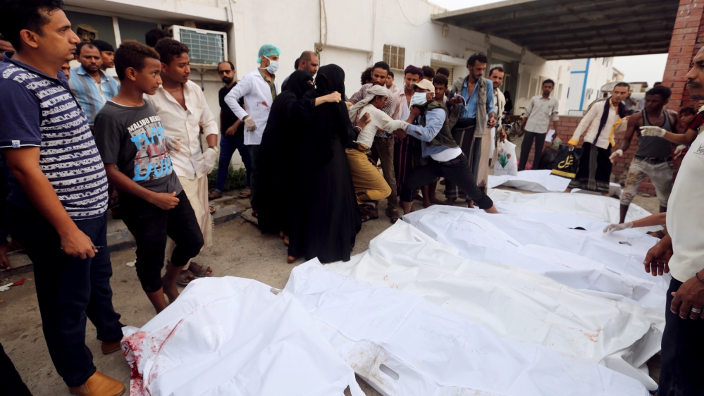 Relatives of victims gather around their bodies outside a hospital morge after an air strike hit a fish market in Hodeidah