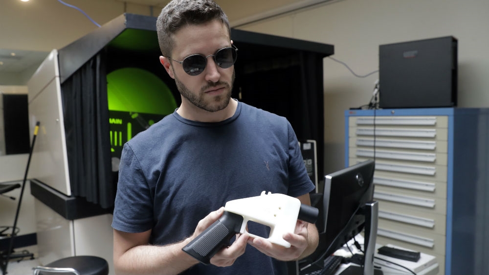 Defense Distributed's Cody Wilson holds a 3D-printed gun called the Liberator at his shop [File: Eric Gay/AP Photo]
