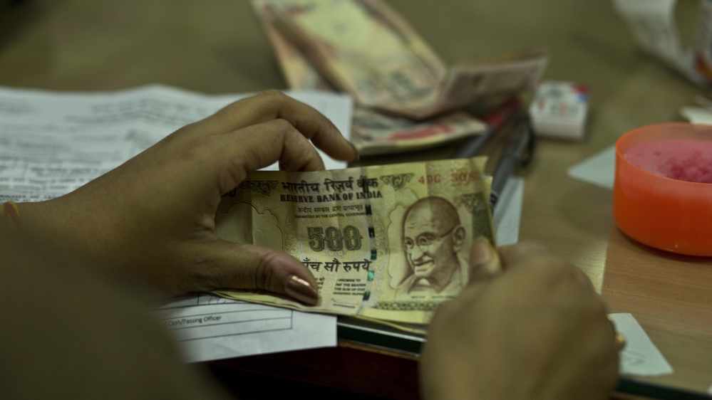 Close-up of an Indian bank official's hands as they count discontinued five hundred rupee notes in Gauhati, India.