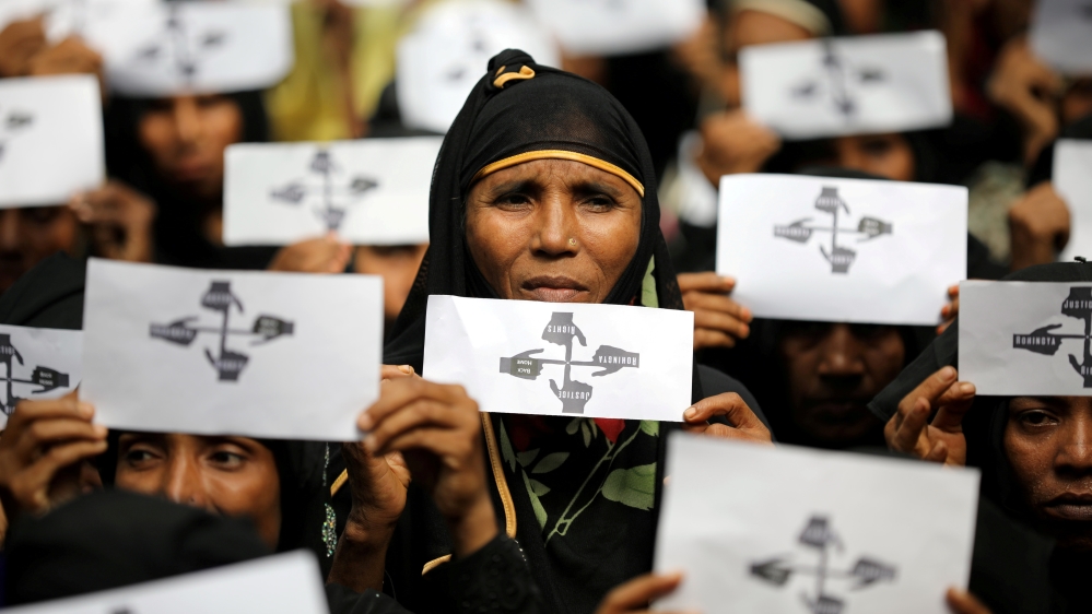 Rohingya refugee women hold placards as they take part in a protest at the Kutupalong refugee camp to mark the one-year anniversary of their exodus in Cox''s Bazar