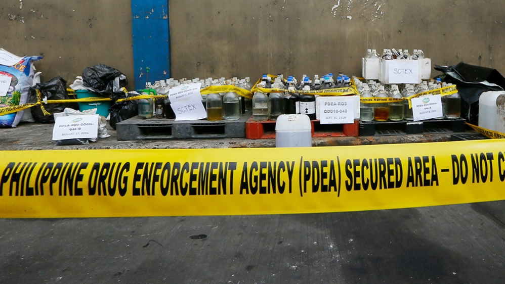 Philippine Drug Enforcement Agency (PDEA) agent prepares to destroy P3.1 million ($62,000) worth of chemicals and laboratory equipment which were seized recently in President Rodrigo Duterte's unrelen