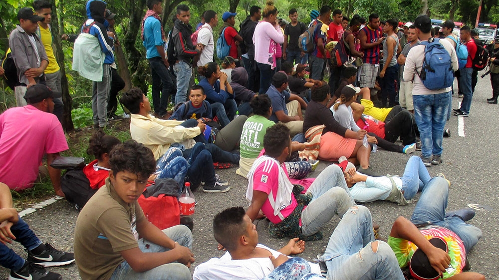 
Dozens of Hondurans rest at the side of the highway north of Esquipulas while waiting for directions from Guatemalan police special forces halting their advance [Sandra Cuffe/Al Jazeera] 