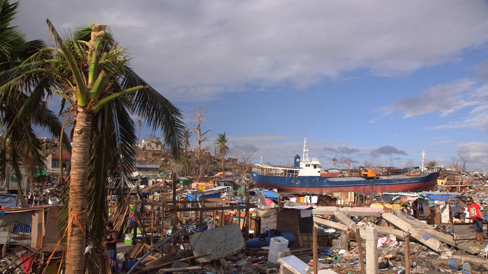 A cargo ship washed ashore by Typhoon Haiyan's waves sits among the debris in Tacloban, Philippines. [Al Jazeera]