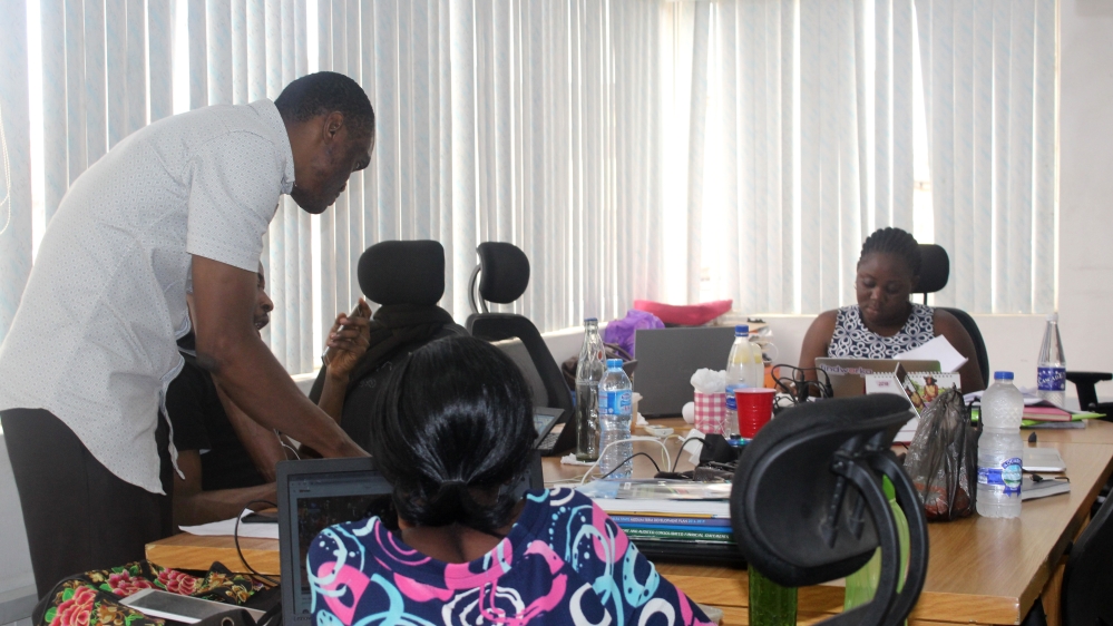 The team at Tracka work on reports submitted by tracking officers [Linus Unah/Al Jazeera]