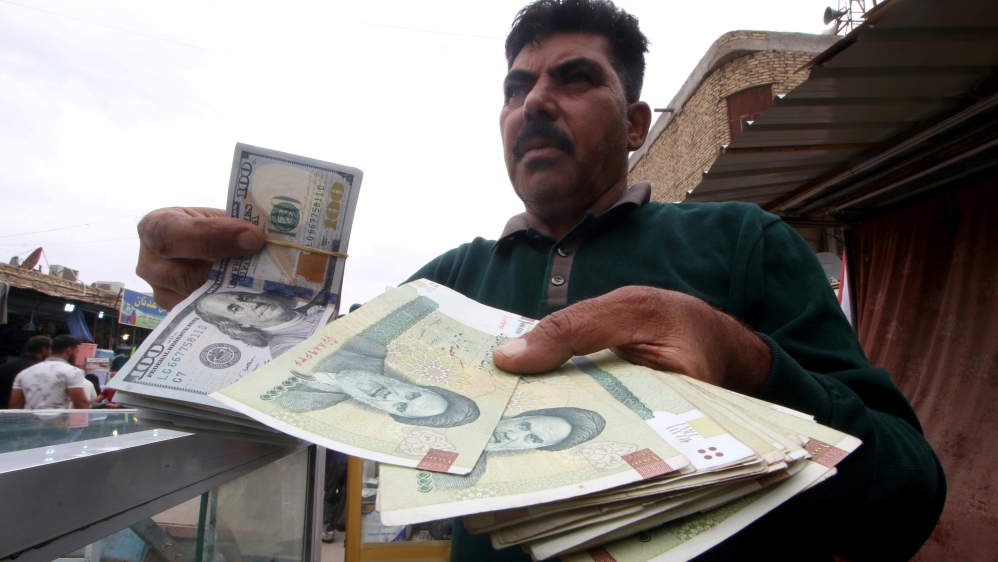 A man holds Iranian rials at a currency exchange shop, before the start of the U.S. sanctions on Tehran, in Basra
